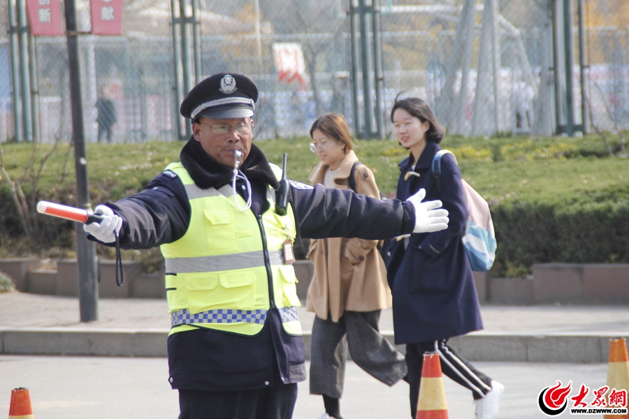 圖2、15日上午11時(shí)41分許，楊秀山在致遠(yuǎn)路上指揮過往的車輛以及下課了的學(xué)生。大膽走、向前走、快點(diǎn)走，這是楊秀說的山上崗工作時(shí)最多的話。.jpg